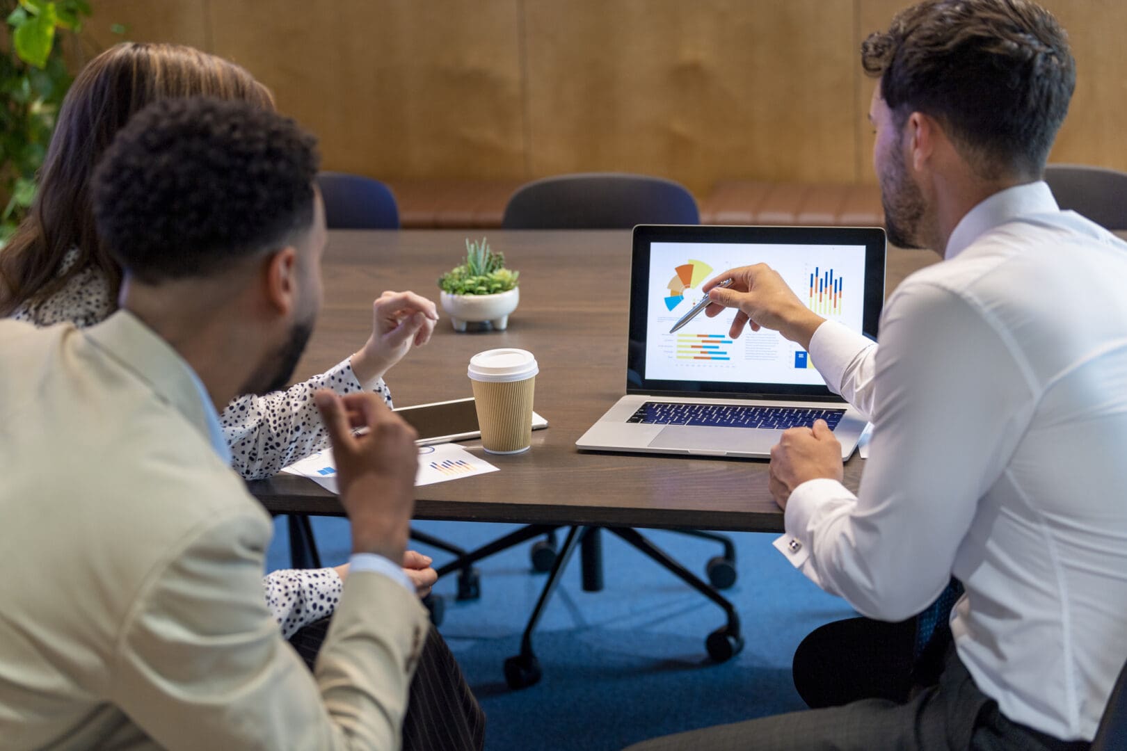 Team discussing charts on laptop