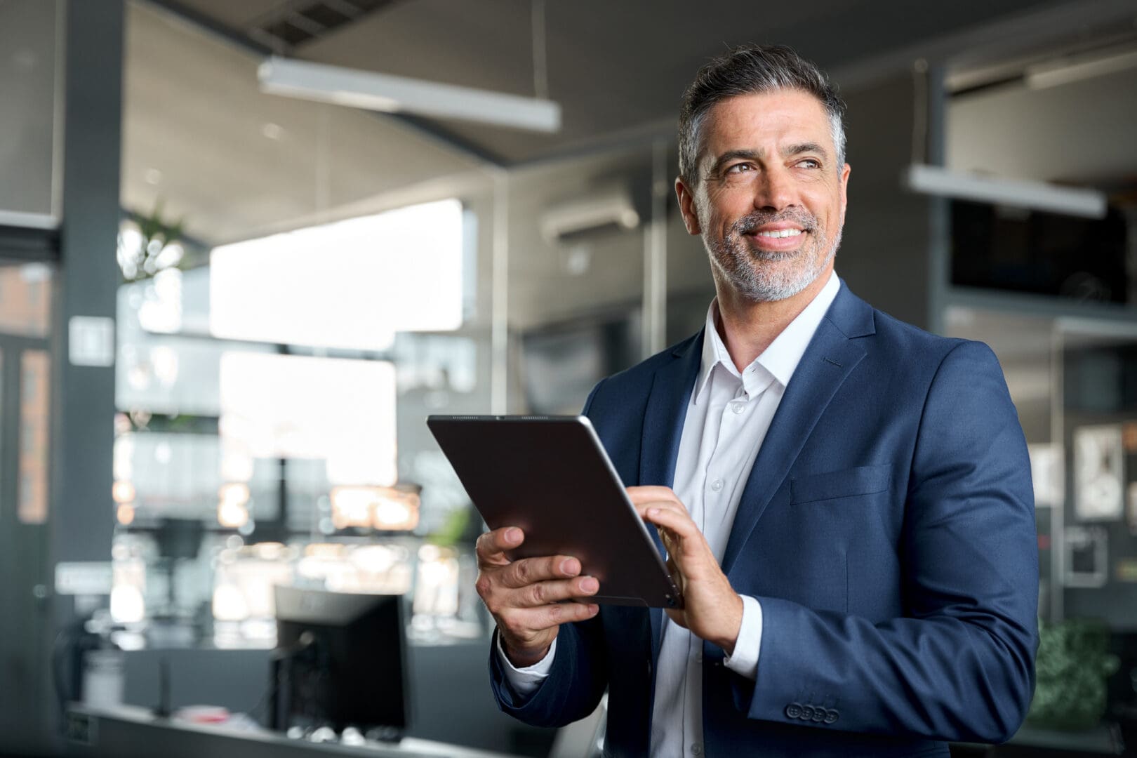 Businessman smiling while holding a tablet