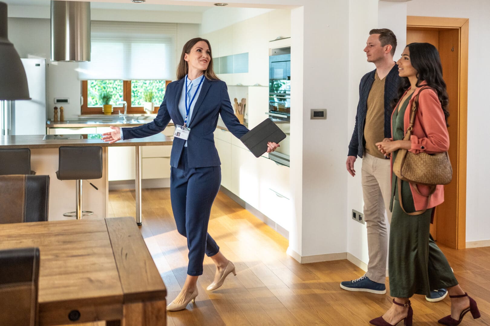Realtor showing couple modern kitchen