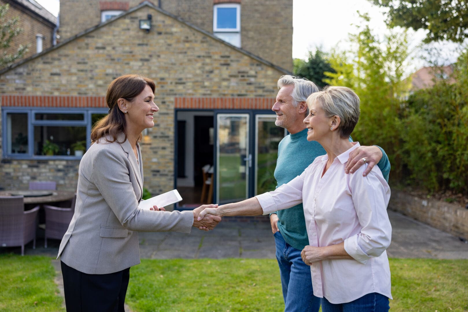 Homebuyers shaking hands with realtor.