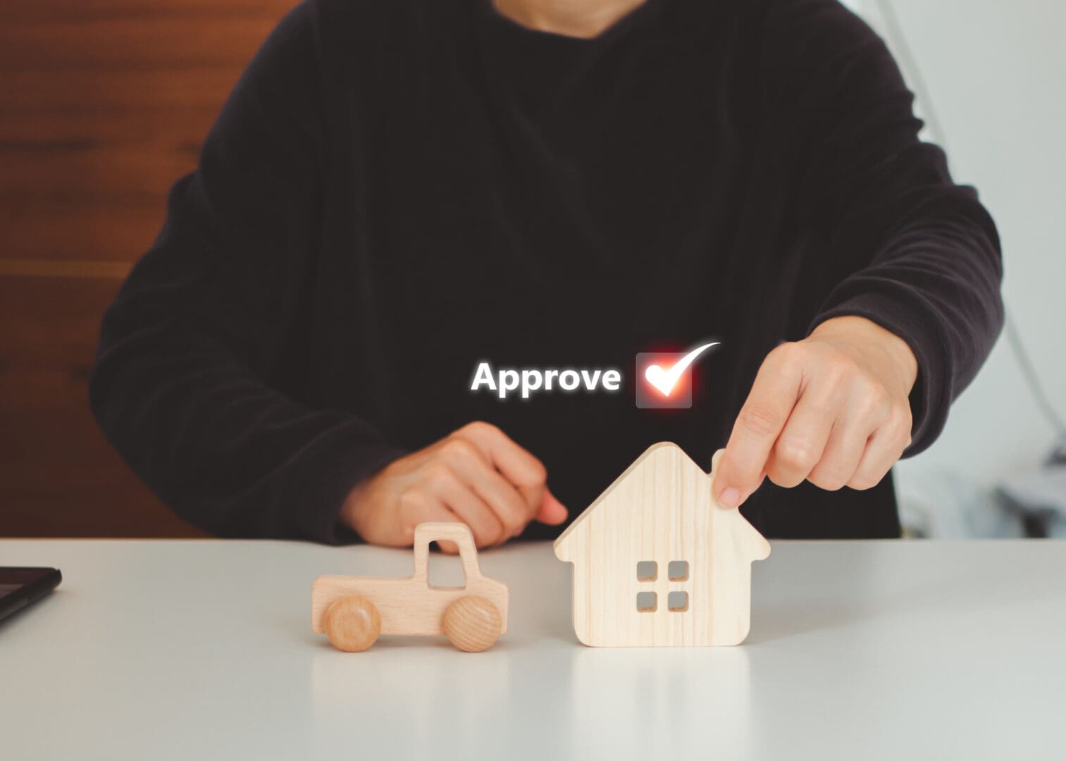 Hand approving house model with checkmark