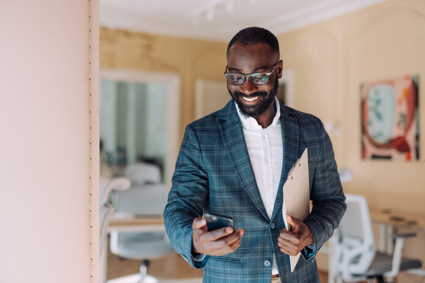 Businessman holding folder and phone, smiling