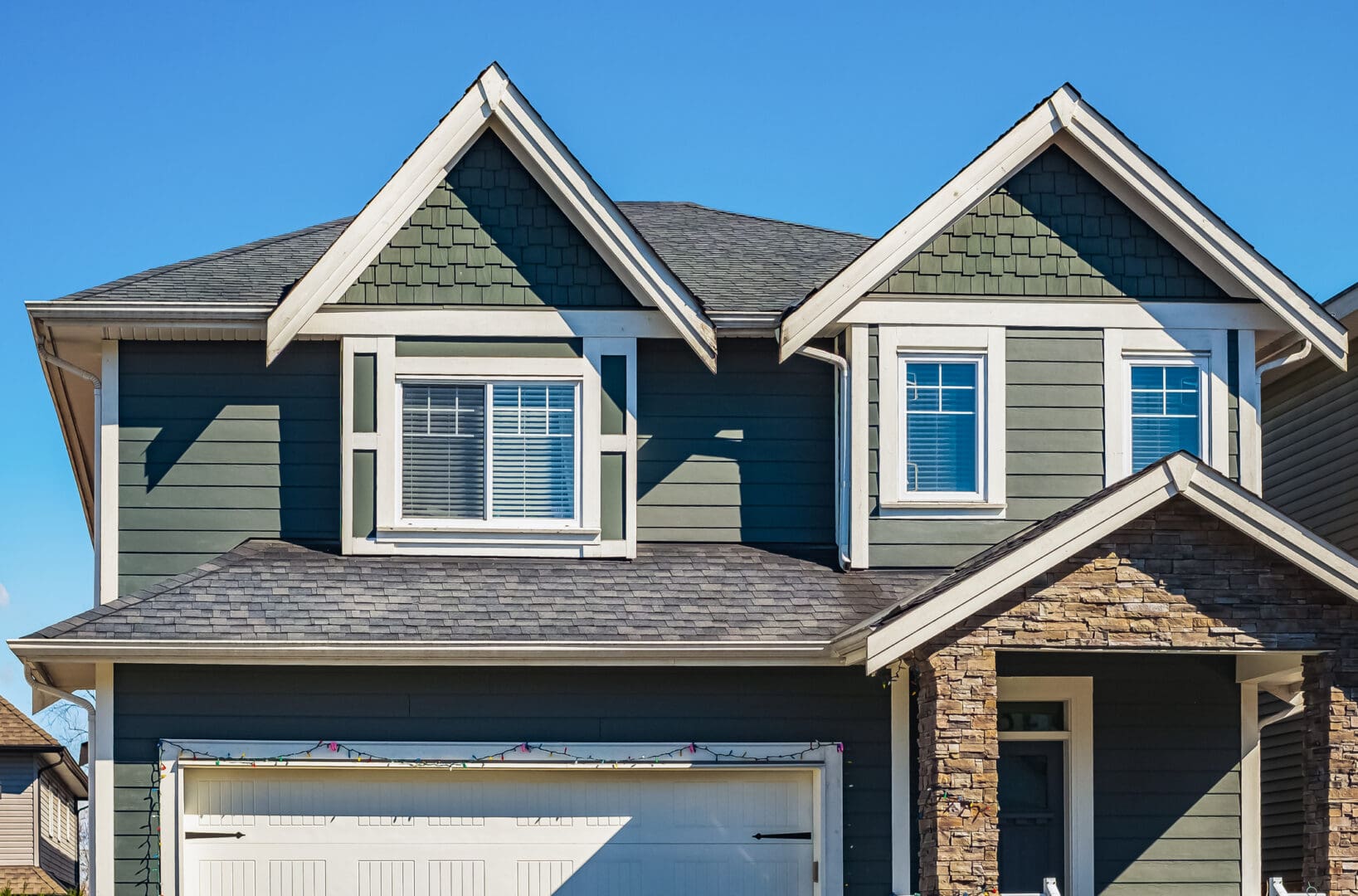 Green suburban house with gabled roof