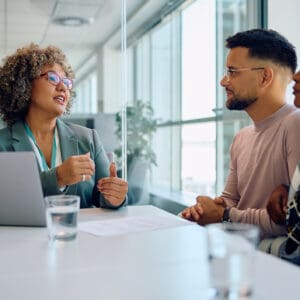 Two colleagues having a thoughtful discussion in a modern office.