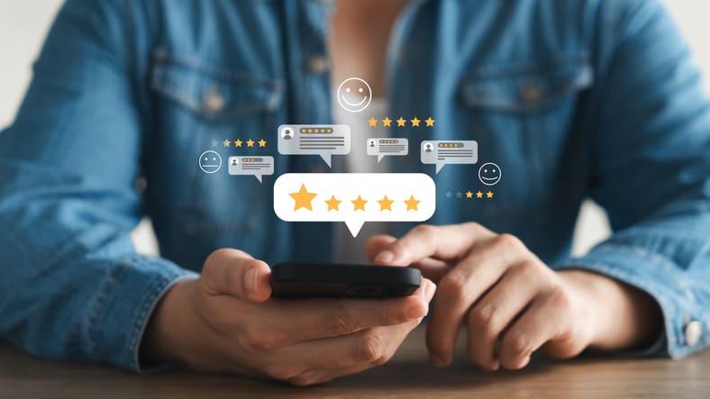 Person using smartphone to give star ratings and reviews.