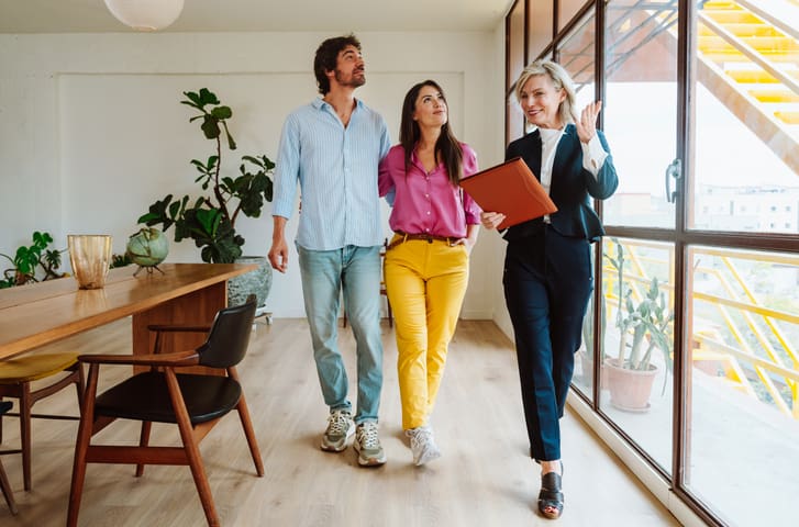 Three professionals walking and discussing in a modern office.