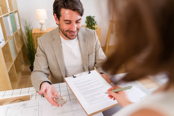 Man discussing details with a woman holding a clipboard.