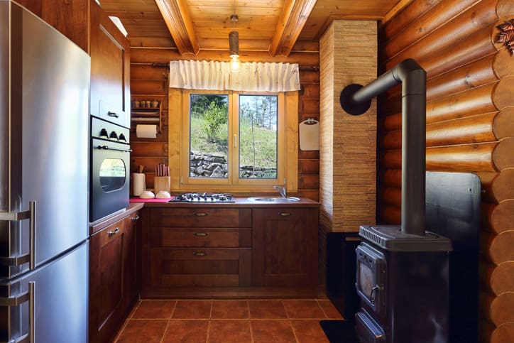 Cozy rustic kitchen with wooden cabinets and a wood-burning stove.