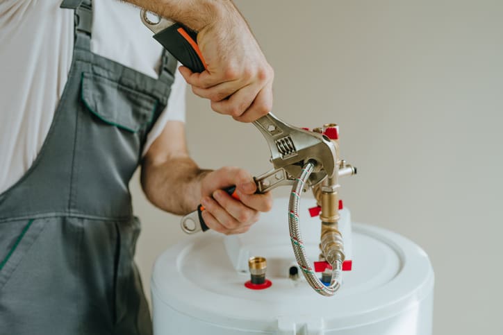 Technician assembling a mechanical component with tools.