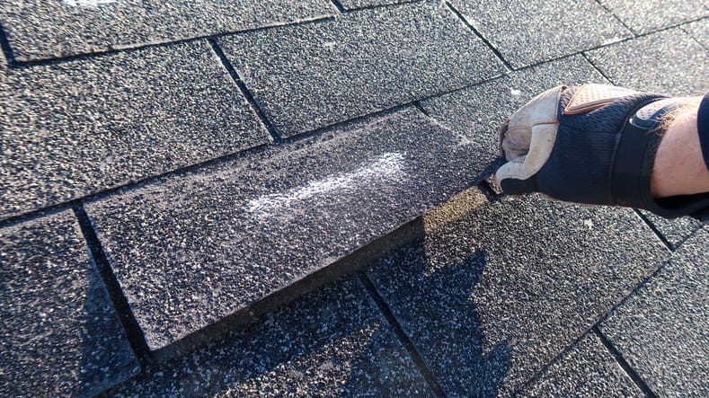 Person cleaning a chalk arrow on a stone bench outdoors.