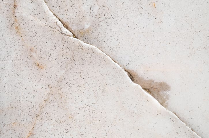 Close-up of cracked, textured white surface with subtle stains.