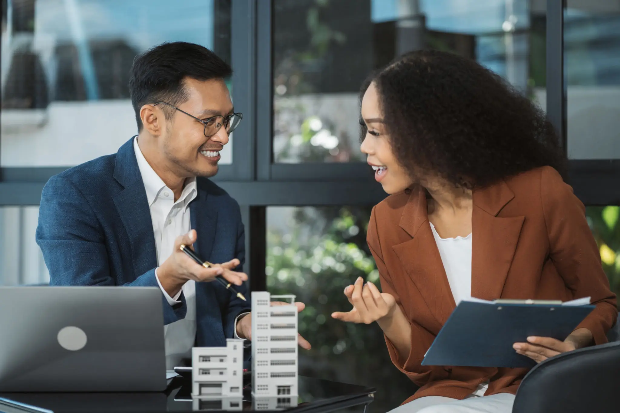 Two professionals discussing architectural models