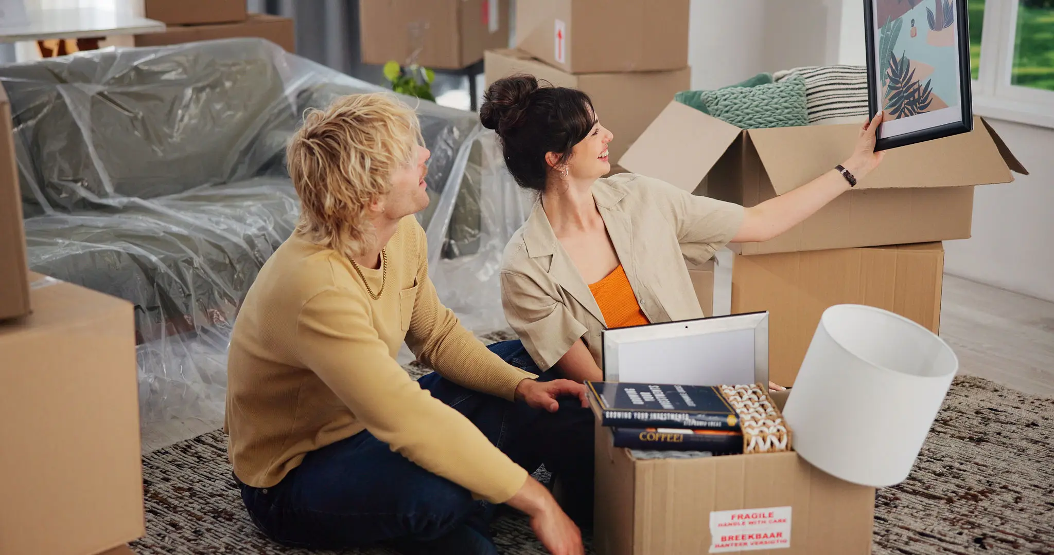 Couple unpacking boxes in new home