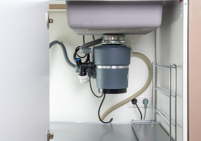 Installed garbage disposal unit under kitchen sink.