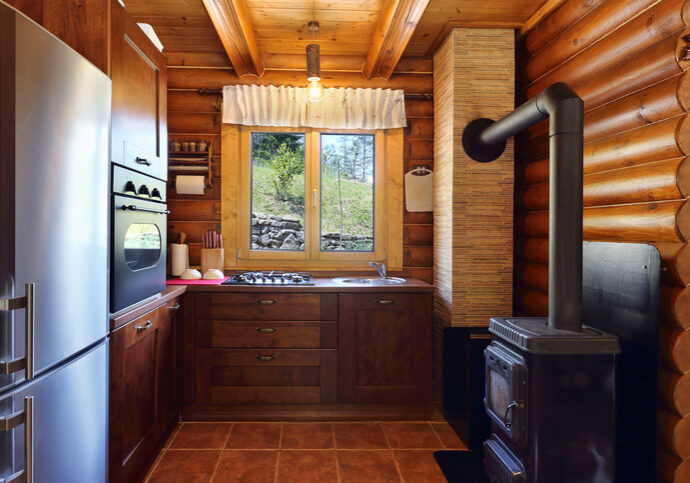 Cozy rustic kitchen with wooden cabinets and a wood-burning stove.