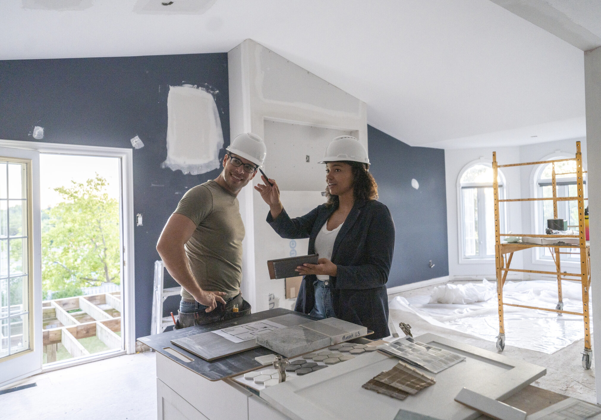 Two people in hard hats at construction site