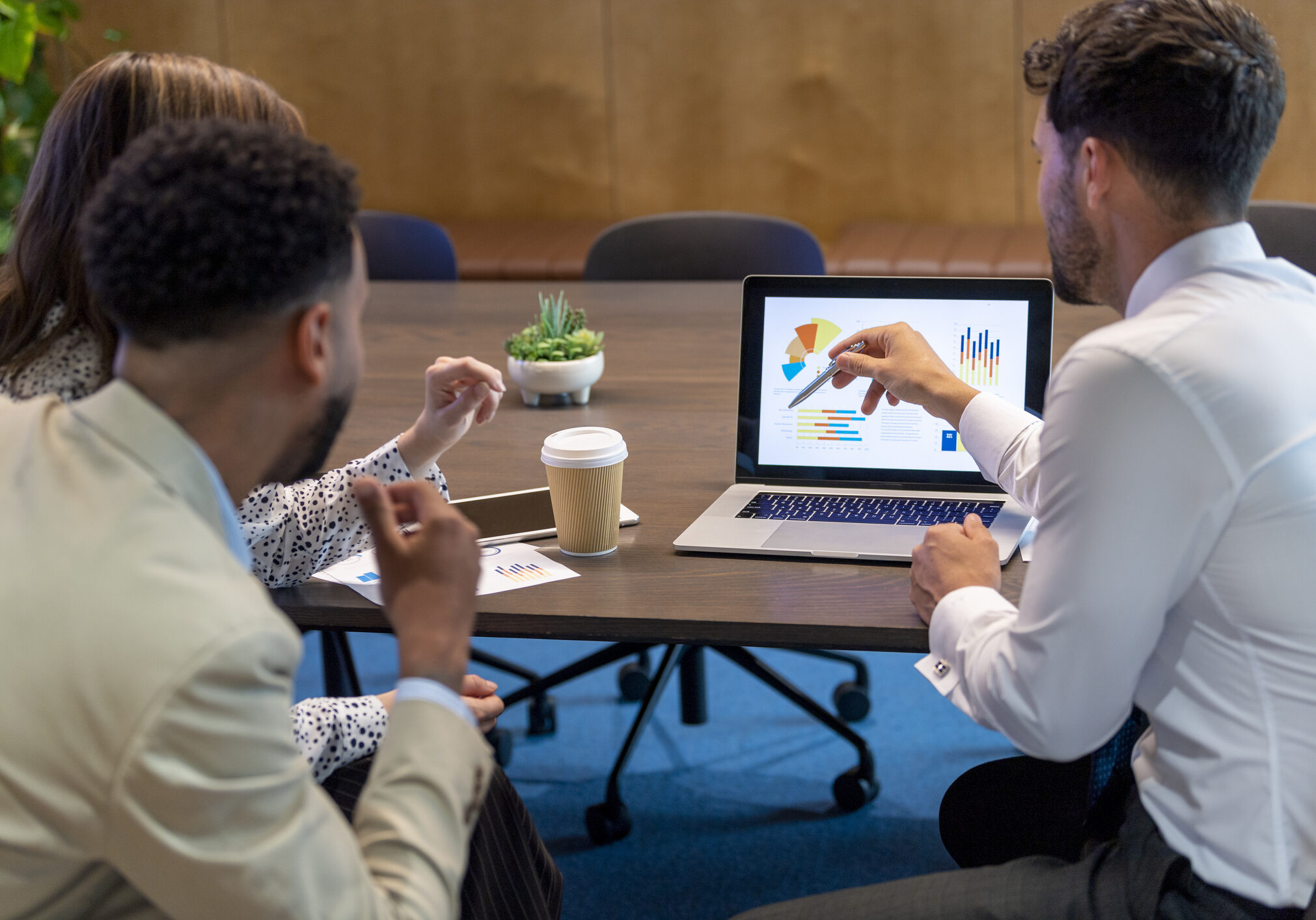 Team discussing charts on laptop
