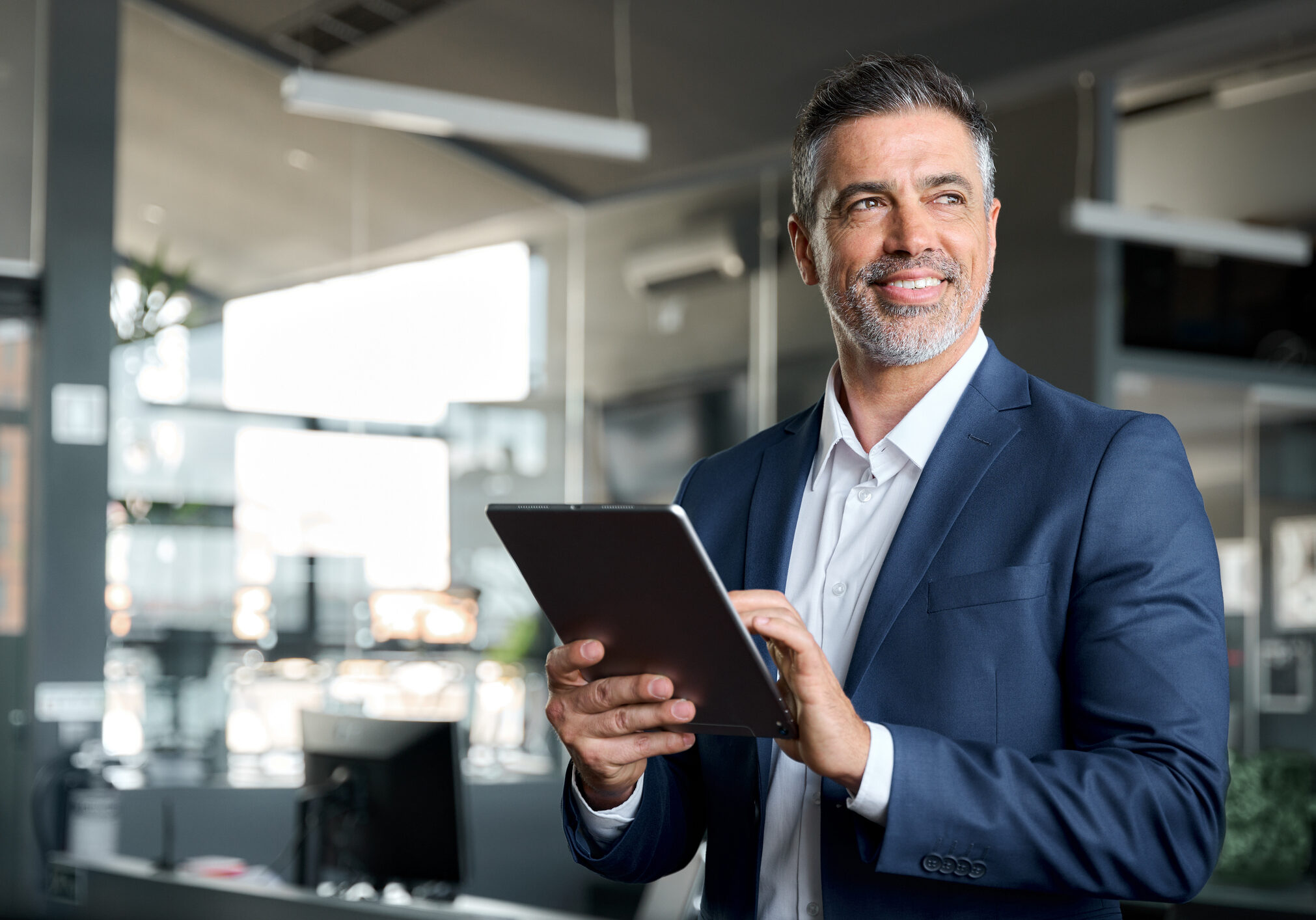 Businessman smiling while holding a tablet