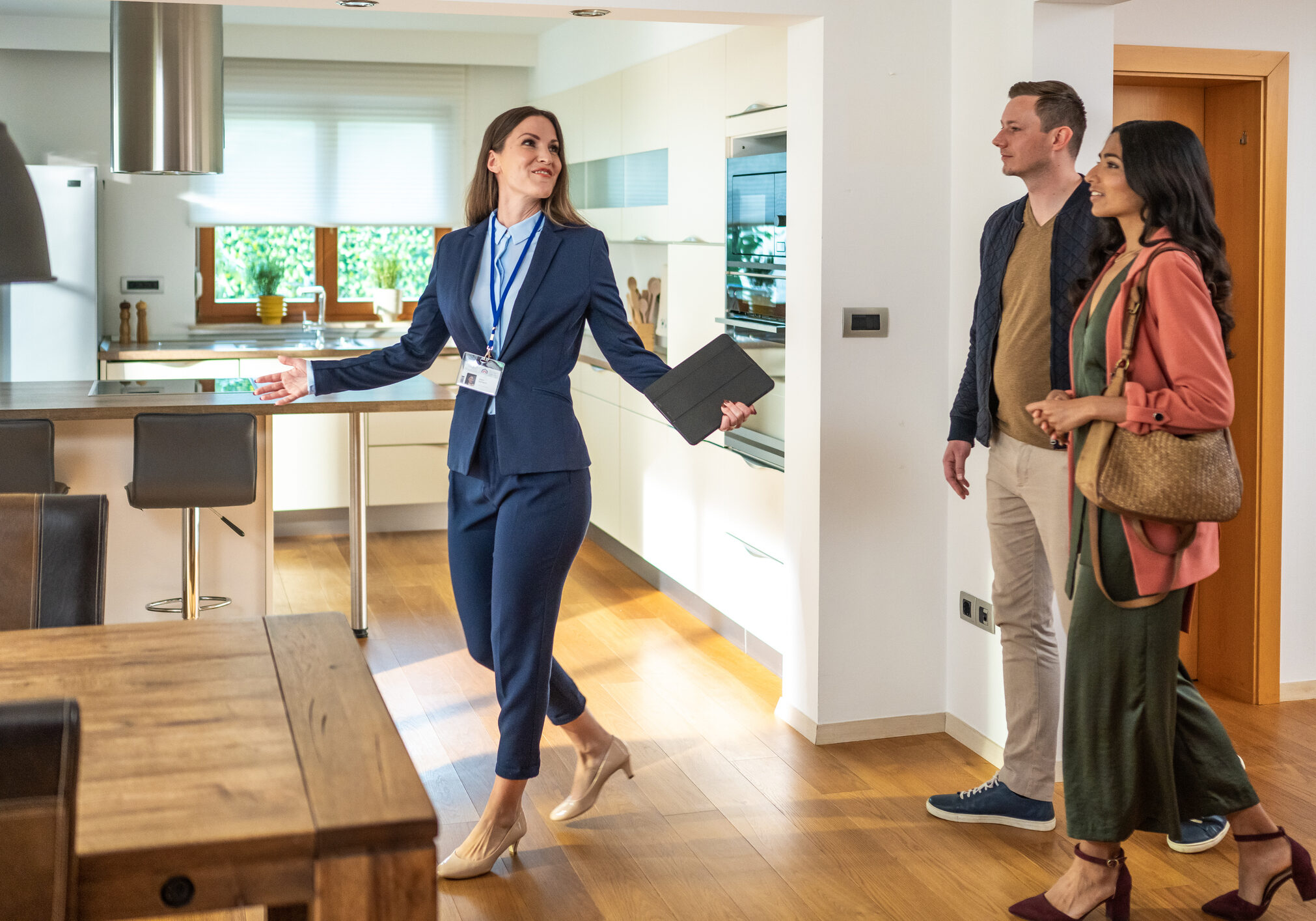 Realtor showing couple modern kitchen