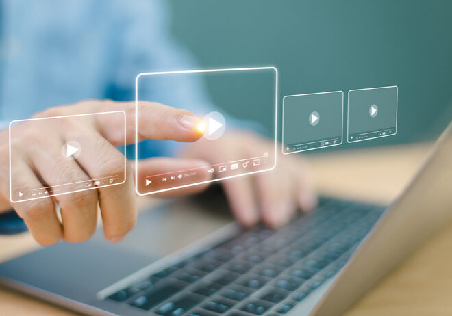 Hand interacting with a virtual touchscreen above a laptop keyboard.