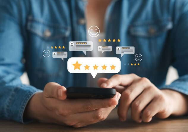Person using smartphone to give star ratings and reviews.
