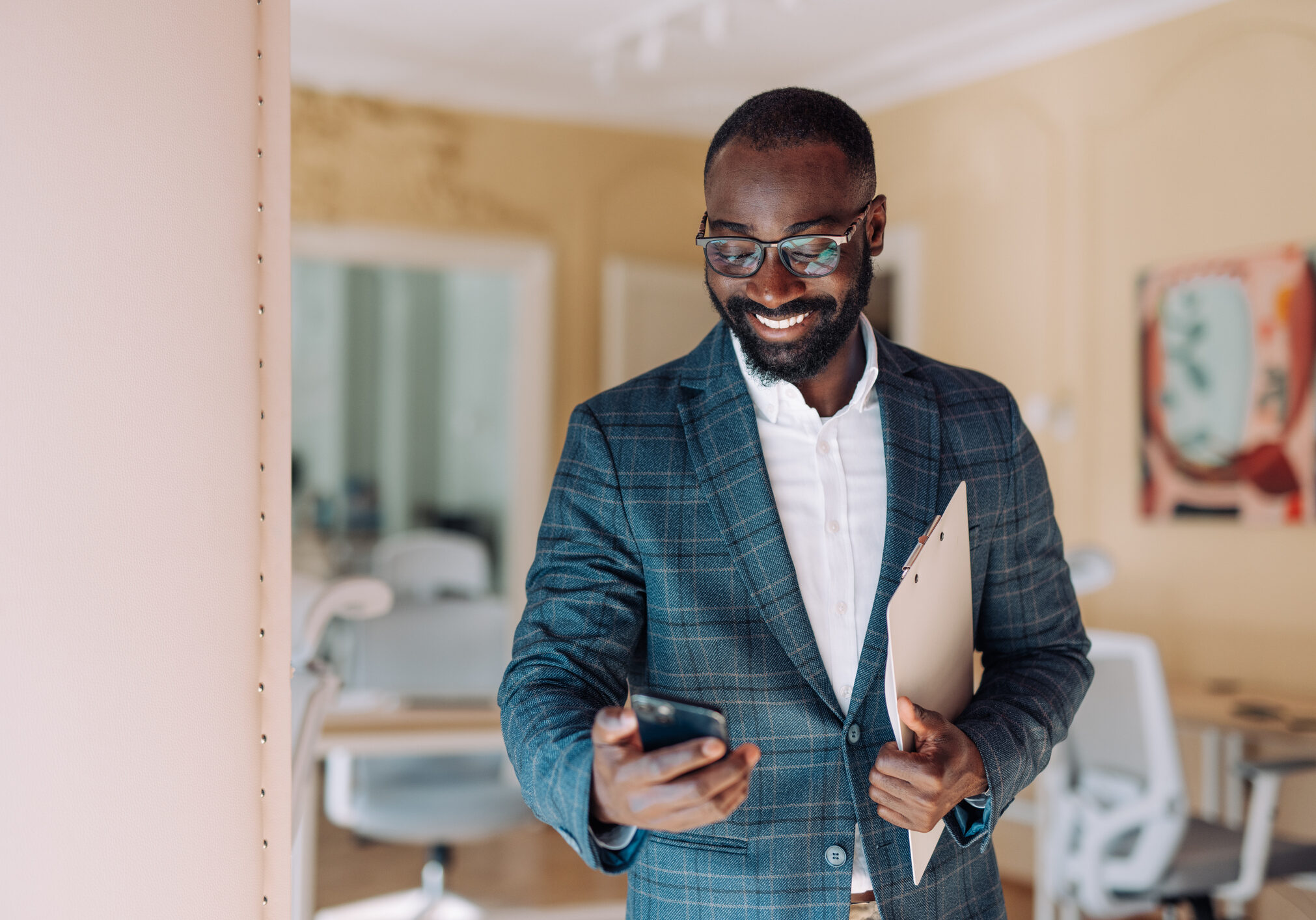 Businessman holding folder and phone, smiling