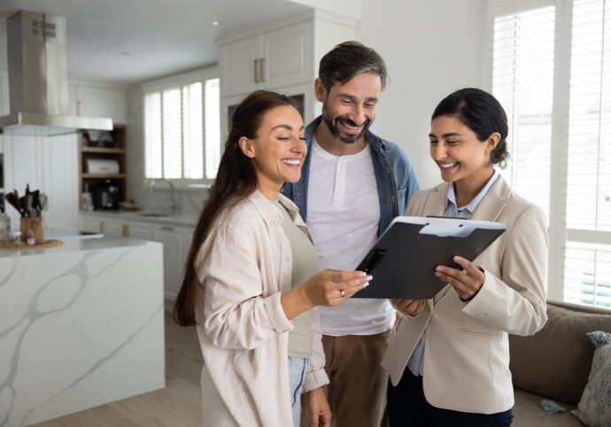 Real estate agent showing home details to a couple inside a house.
