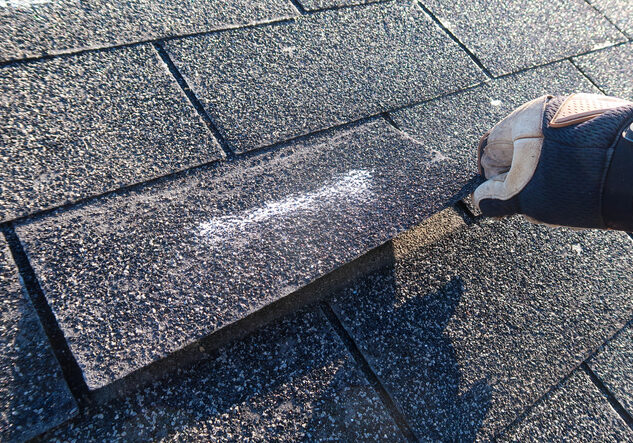 Person cleaning a chalk arrow on a stone bench outdoors.