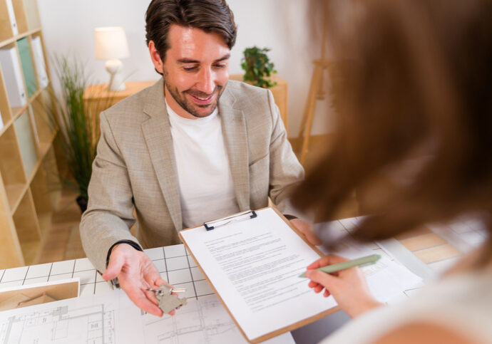 Man discussing details with a woman holding a clipboard.