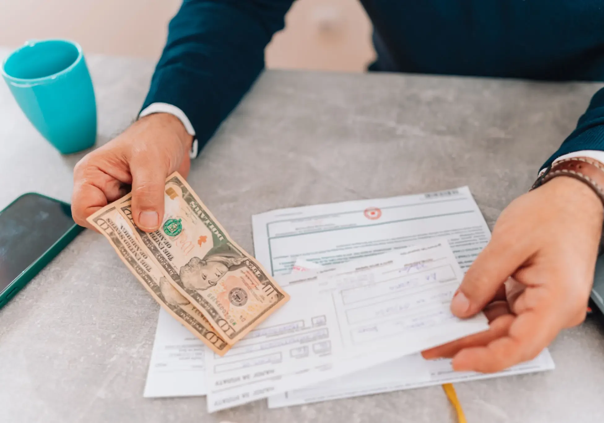 Person handing cash while filling paperwork