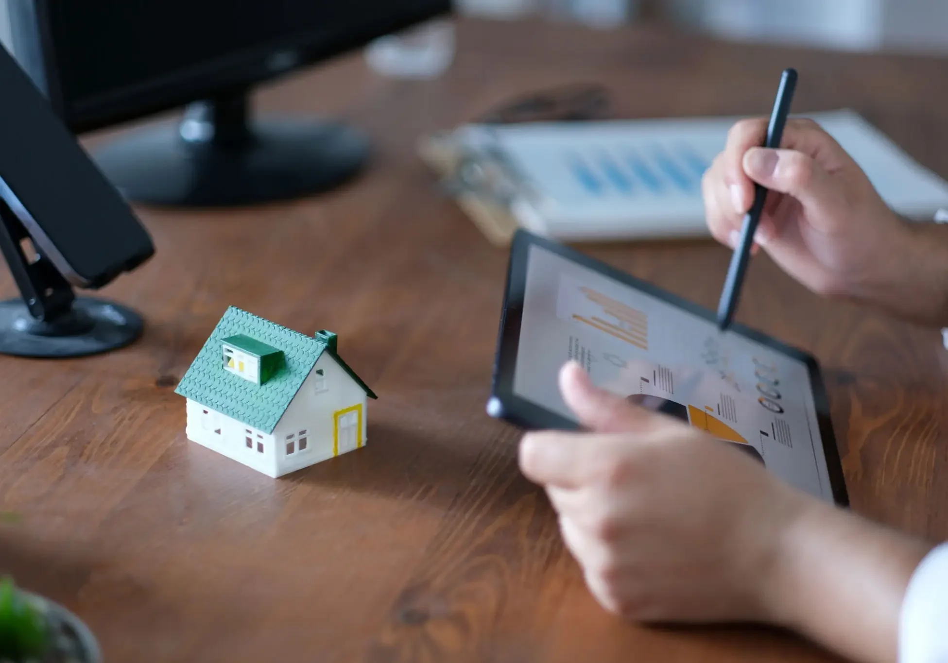 Model house next to person using tablet