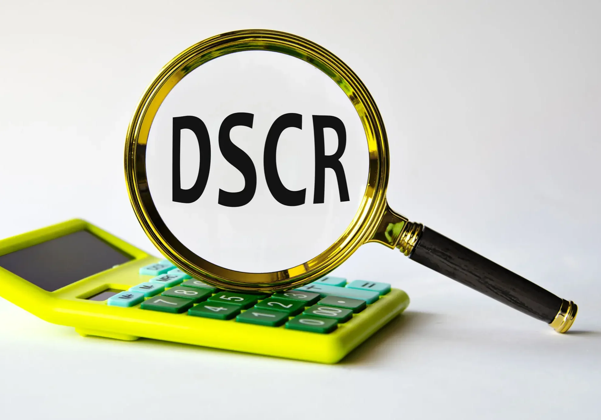 Magnifying glass focusing on DSCR over calculator