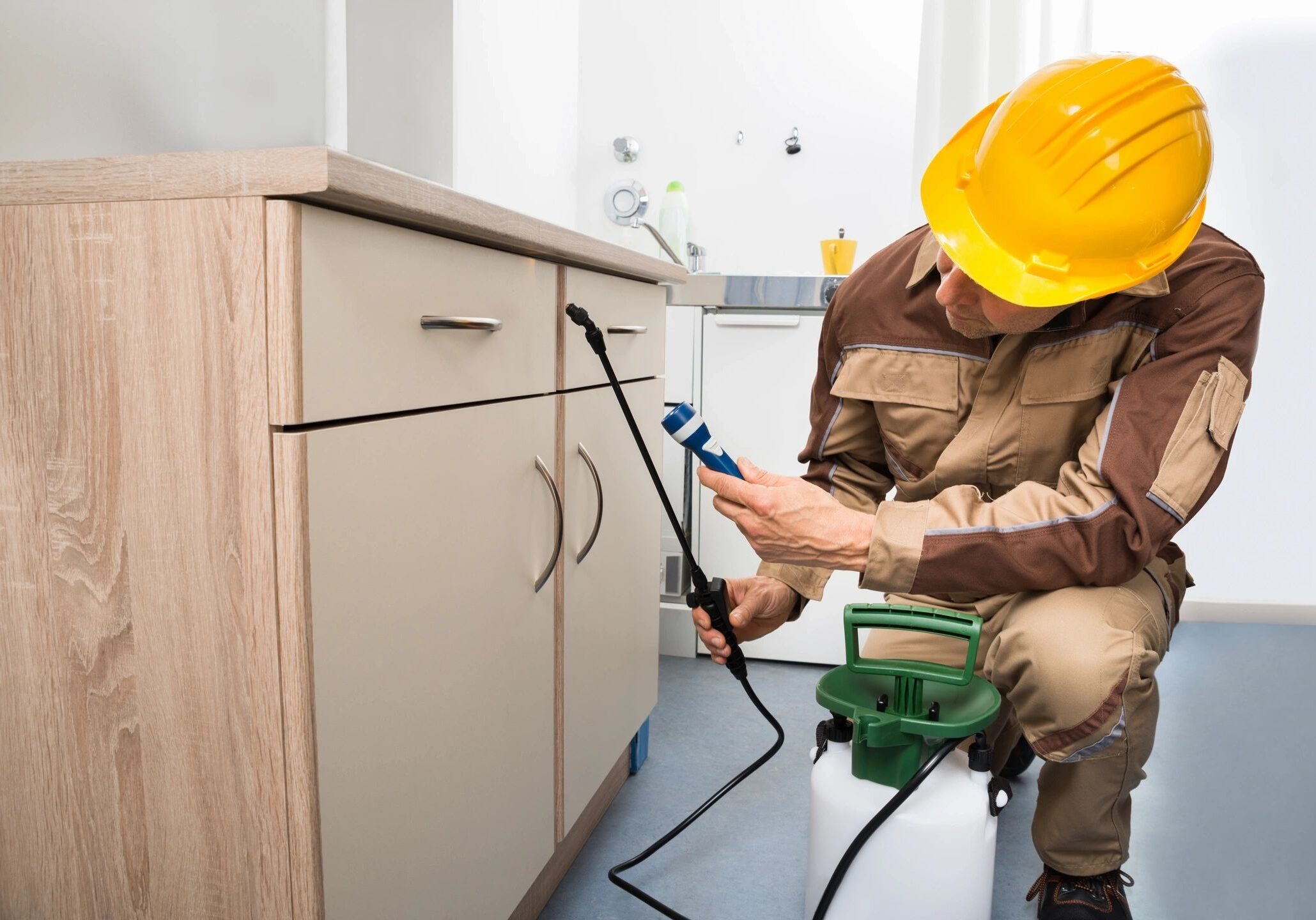 Technician repairing cabinet door with power tool.