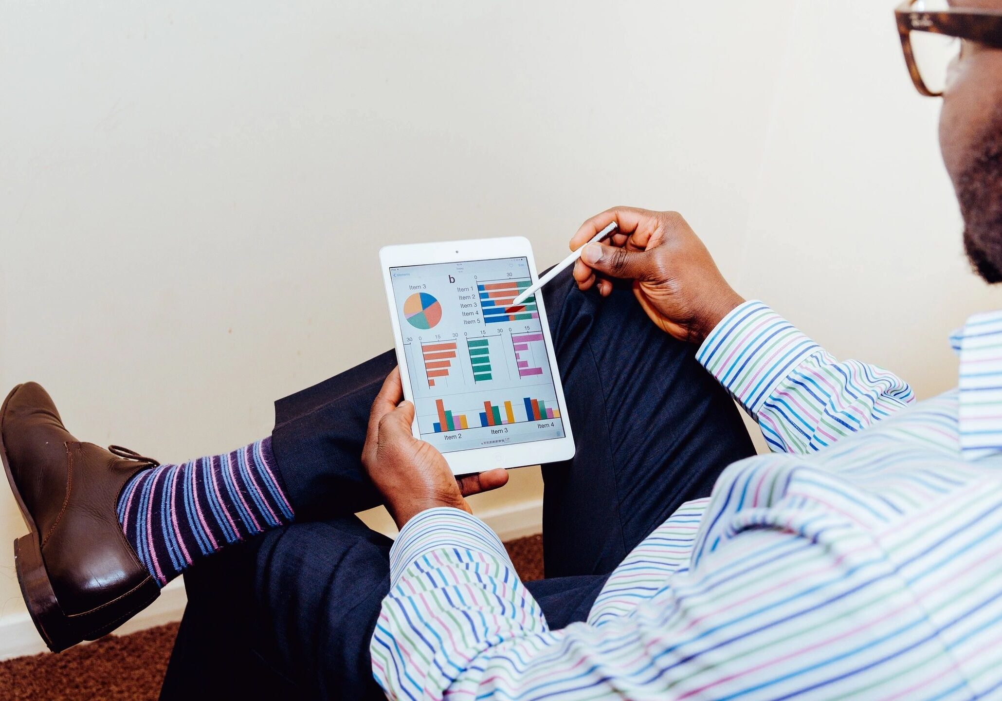 Person analyzing data charts on a tablet.