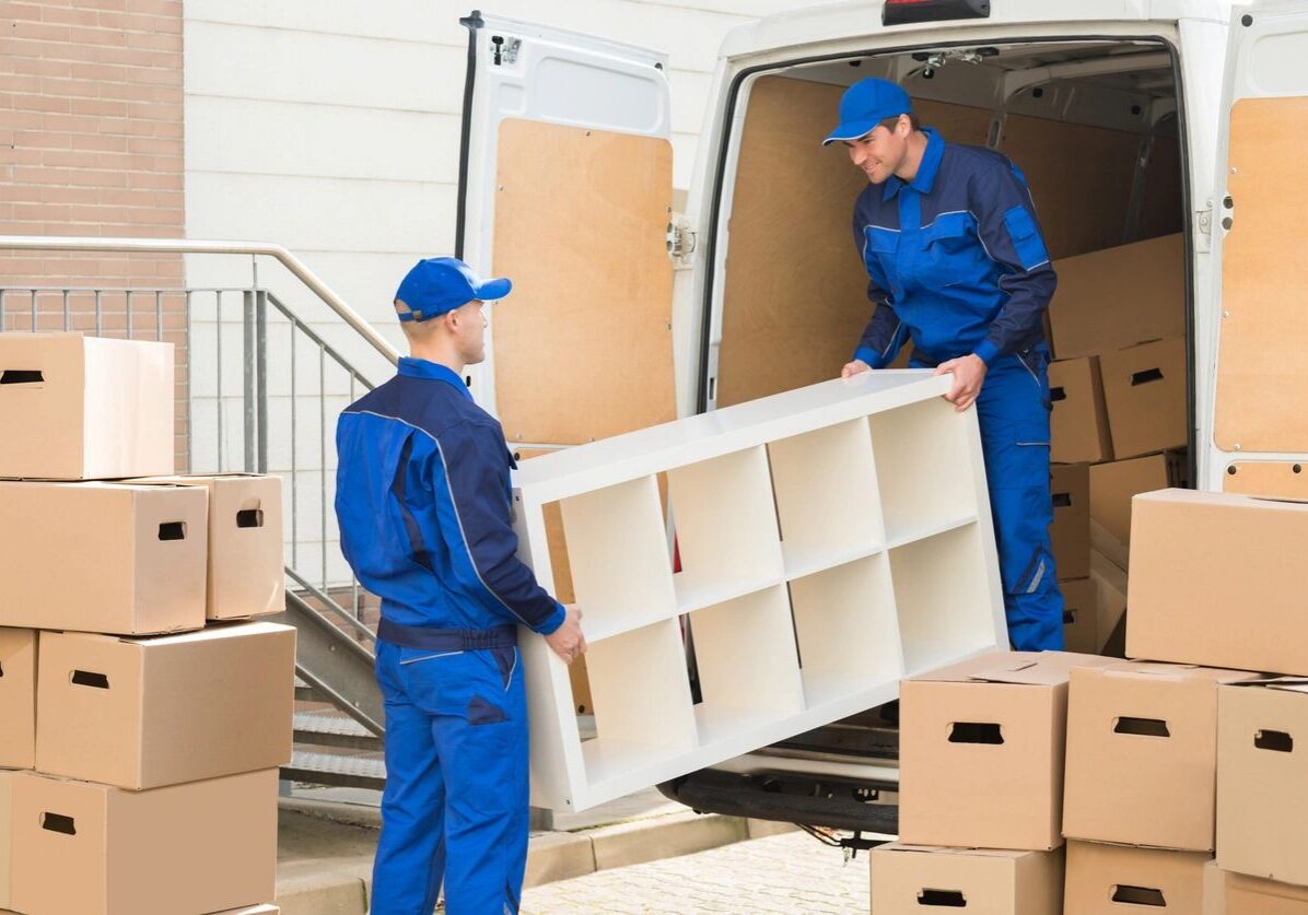 Two movers loading furniture into a truck.
