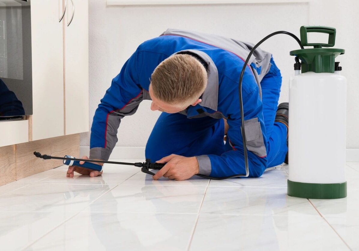 Technician repairing a floor tile indoors using tools.