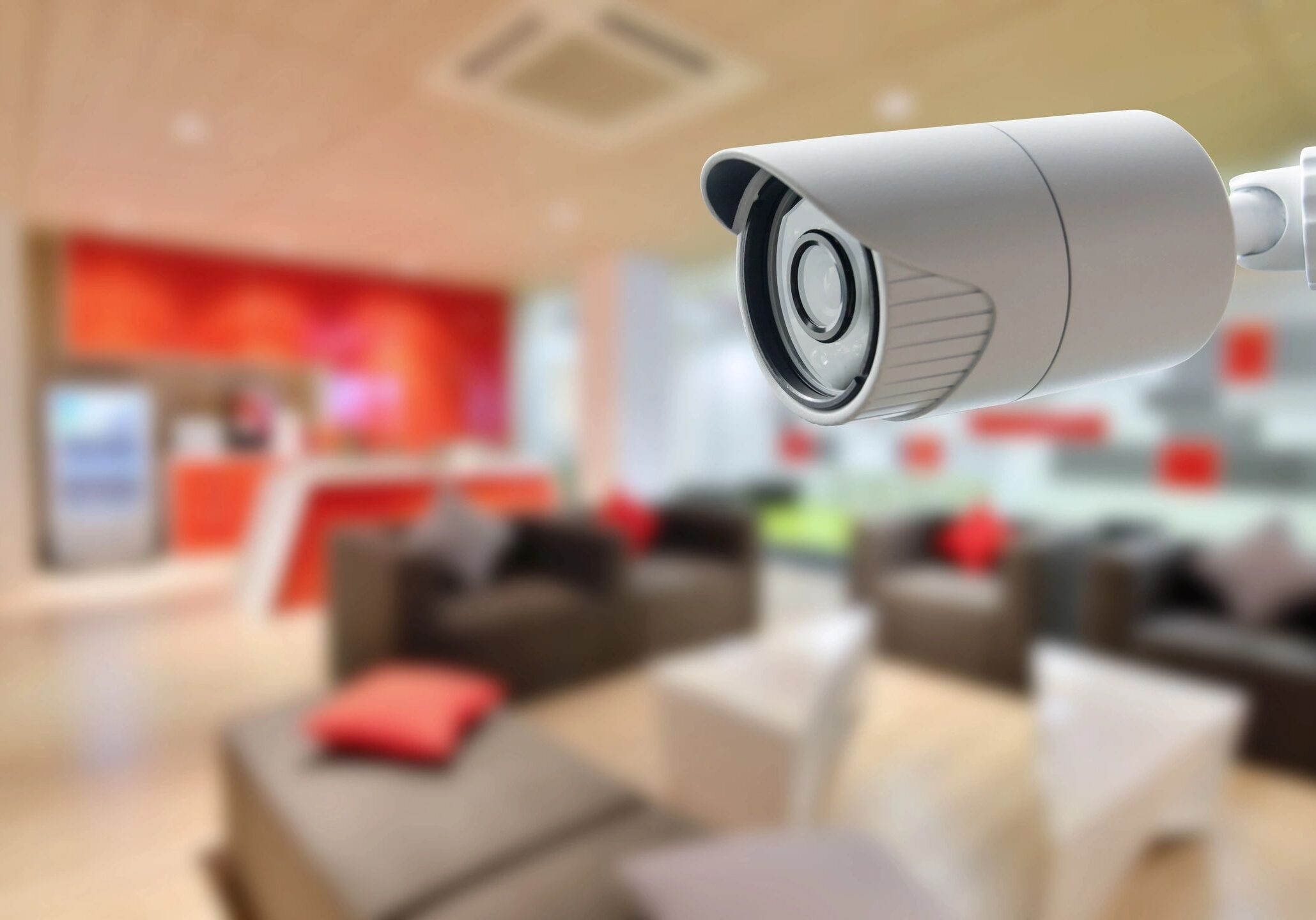 A security camera overlooking a cozy living room with red accents.