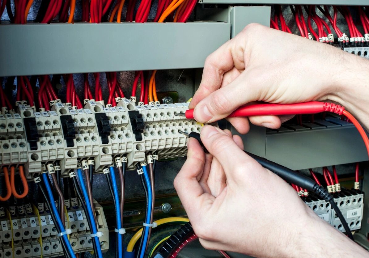 Electrician connecting wires in a circuit breaker panel.