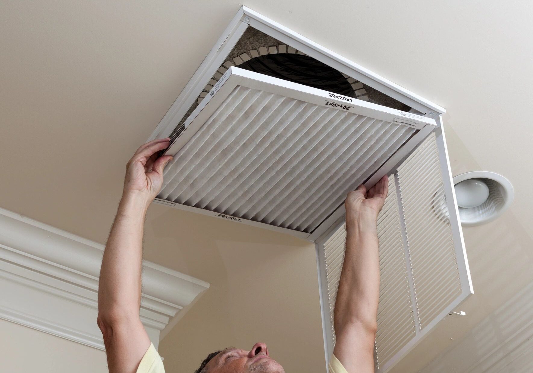 Person installing or removing a ceiling vent cover.