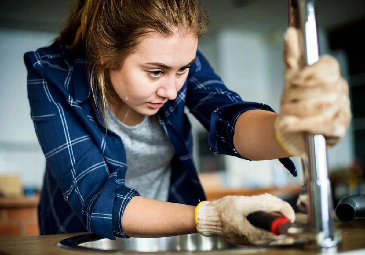 Young woman focused on a woodworking project indoors.