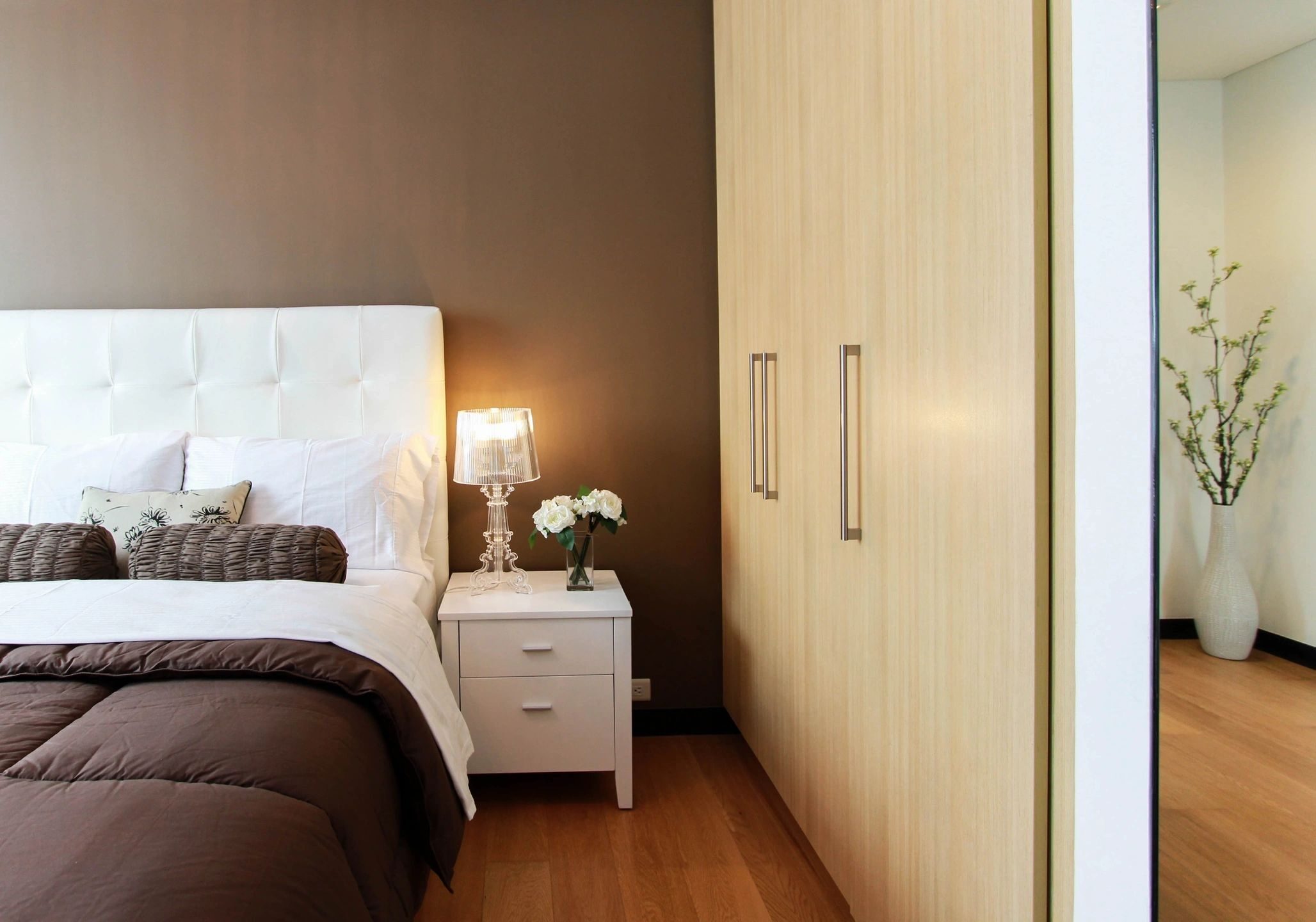 Cozy bedroom corner with a bed, nightstand, and wardrobe.